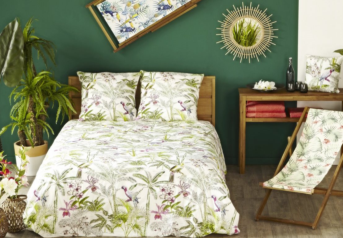 Jungle style with flowered bed linen and a sun mirror