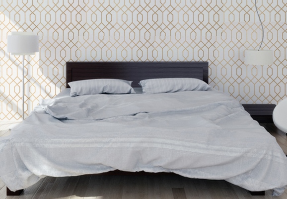 Bed with modern wallpaper with golden patterns