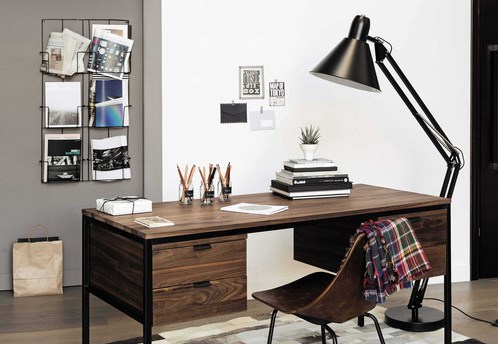 Office with a wood desk and a wall mount magazine rack