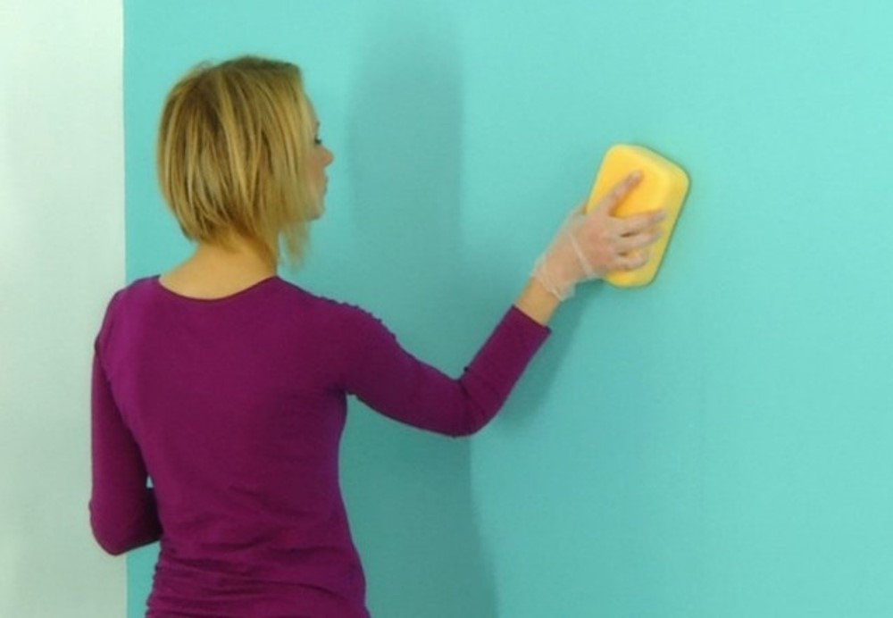 Woman cleaning a painted wall